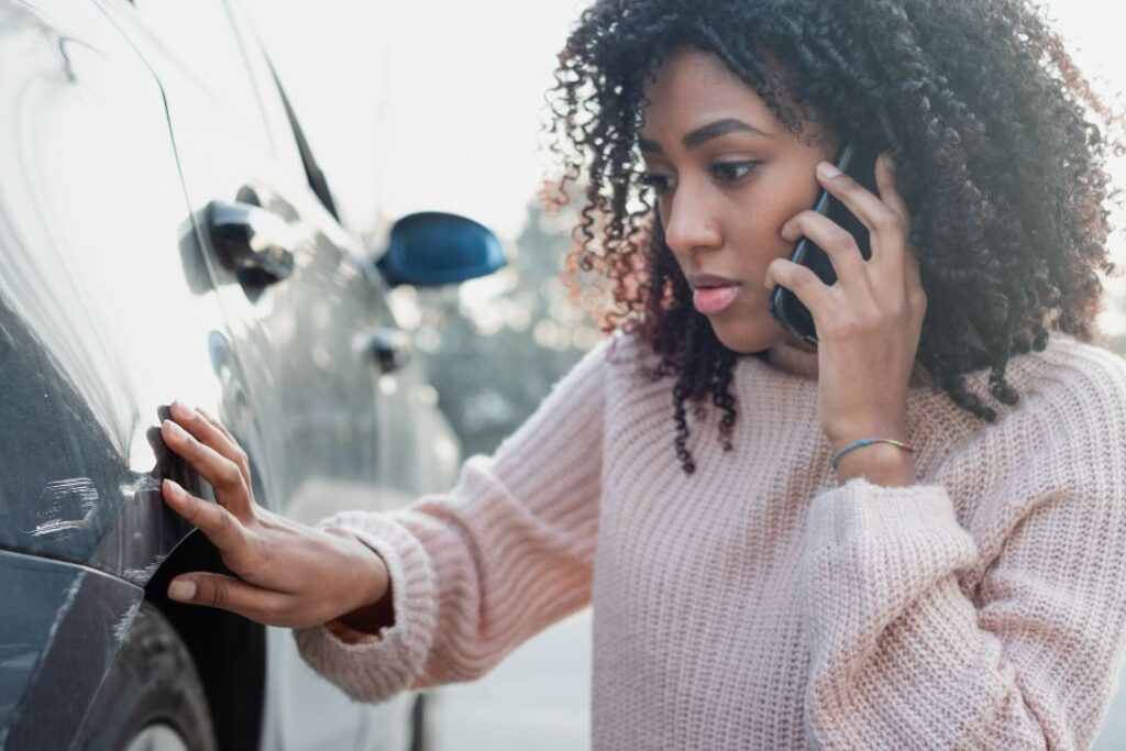 Black woman making a phone call after being involved in an Amazon truck accident in the Houston, TX