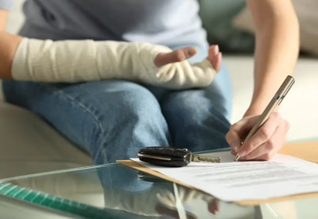 Woman signing insurance documents after being in a car accident